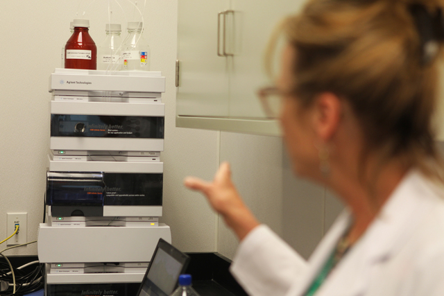 Dr. Cindy Orser, CSO for DigiPath Labs, shows a liquid chromatography system inside the analytical room.
